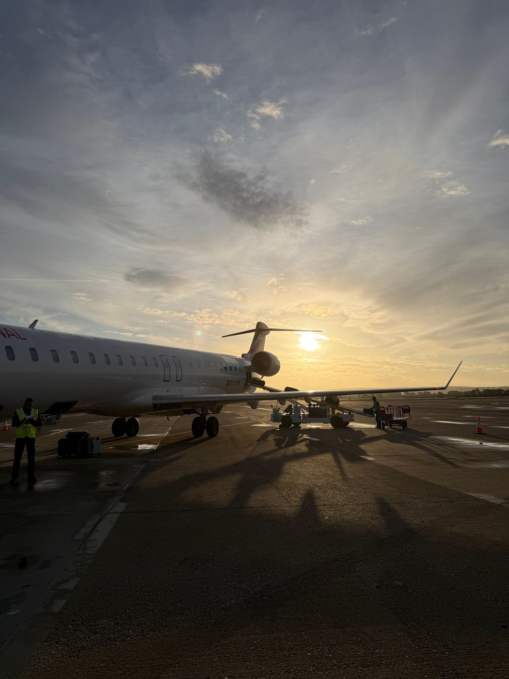 An airplane on the runway at sunset